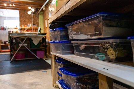 A close-up view of plastic containers on shelves inside a fashion atelier, filled with textile offcuts and neatly organized for easy access and storage space.の写真素材