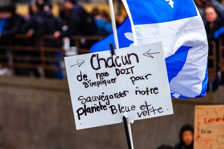 A French placard reads each of us must get involved to safeguard our blue and green planet, seen...