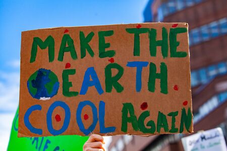 A close up view of a cardboard sign, saying make the earth cool again, as ecological activists stage a street demonstration in Montreal, Canada.の写真素材