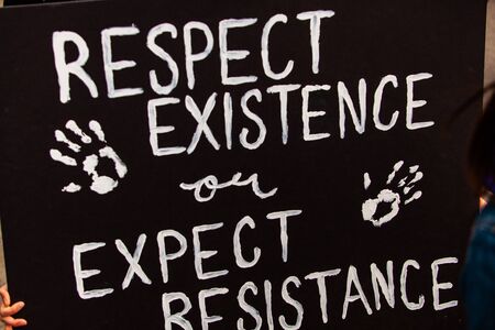 A closeup view of a sign saying respect existence or expect resistance as environmental campaigners...
