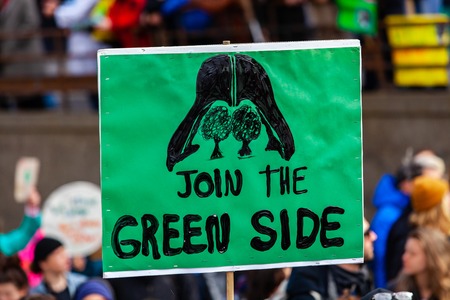 A close up view of a homemade sign during a street rally for the environment, depicting darth vader and saying join the green side.のeditorial素材