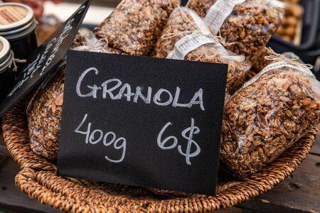 Fresh food at outdoor farmer's market. Healthy bags of granola are seen close up, displayed in a...