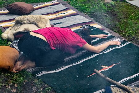 Diverse people enjoy spiritual gathering A young woman is viewed during a shamanic yoga class, in...