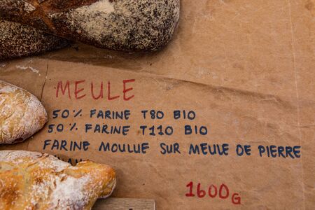 Baked goods at outdoor agriculture fair. French writing, saying flour ground on millstone, is seen...