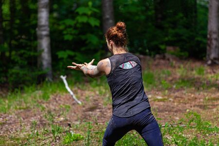 Diverse people enjoy spiritual gathering A young caucasian woman with tattooed arms and back is seen...
