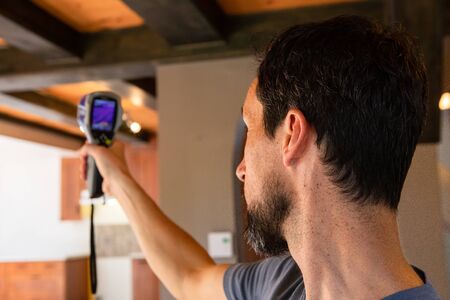Indoor damp & air quality (IAQ) testing. A close up and side view on the head of a building surveyor...