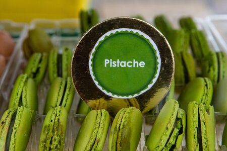 Baked goods at outdoor agriculture fair. A closeup view of green colored pistachio flavored French macaroons for sale during a farmer's market with copy-space.の写真素材