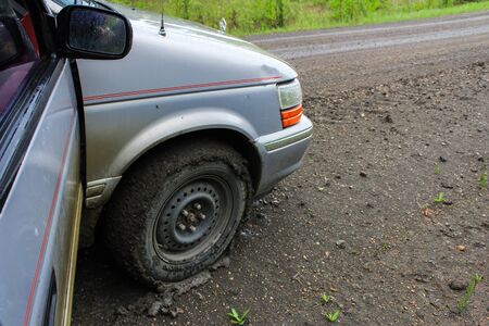 driving on a wet clay road. Closeup picture on the front right wheel of the vehicle, fully...