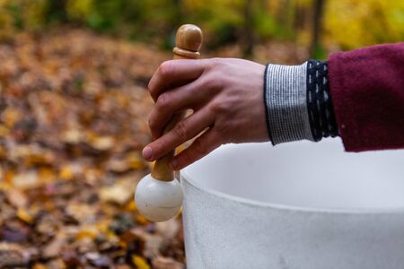 Close up on hand showing the ground. With a blurry background in the fall season
