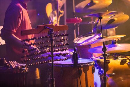Fusion of cultural and modern music event. Drummer playing the drums on stage, close up on...