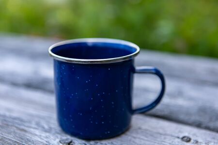 Close up photograph of a large ceramic cup with ear on right side filled with coffee or tea standing...
