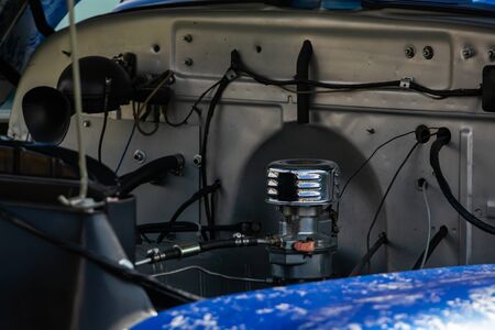 Old classic car under hood, View of chromed carburetor and tubes, wires, pipes, mechanical and...