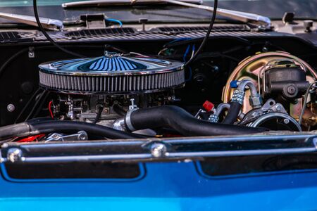 blue classic muscle car under hood close up, big chrome round air intake filter, Engine and Radiator parts, tubes, wires, pipes, Brake vacuum servoの写真素材