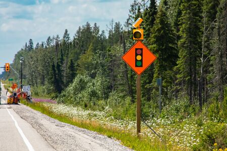 Temporary condition road warning signs on the roadside before road work zone, signal traffic lights...