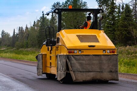 A close up shot of an industrial pneumatic ride on road roller, used to flatten and compact the...