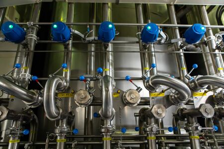 serving vessels handles and bright beer tanks piping system control and pressure monitoring, beer brewery beerhouse factory equipment and control roomの写真素材