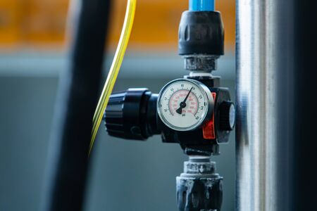 Pressure measurement analogue gauge meter in psi and kPa, vacuum gauges manometer on pipe, selective focus close up view with the needle at 100の写真素材