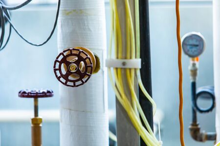 a valve on pipe selective focus view, brewery different piping systems and temperature and pressure measuring devices and electrical wiring backgroundの写真素材