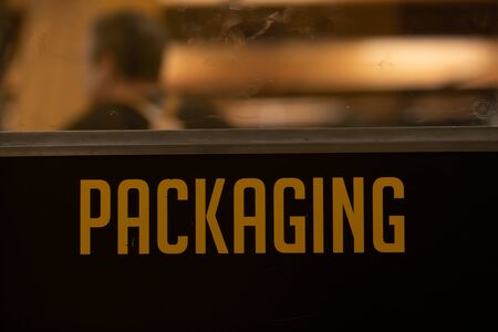 packaging yellow vinyl sticker text Information sign on a black door, industrial room symbol, selective focus and close up viewの写真素材