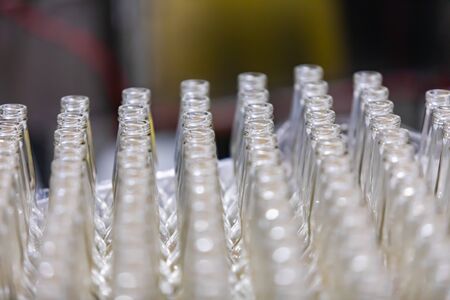 a lot of new beer white glass empty bottles lines selective focus close up view, with copy space, Conveyor belt Craft brewery factory microbreweryの写真素材