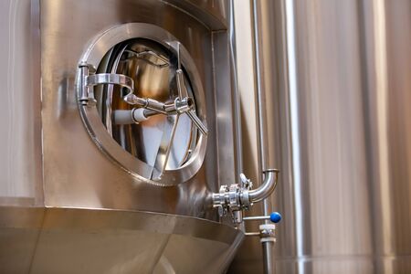 stainless steel tank, vessel closed rounded side manway, manhole door close up with valve, brewhouse...