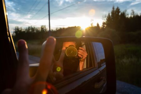 Photographer self portrait taken with a DSLR from the passengers seat of a SUV. Lens flares and...