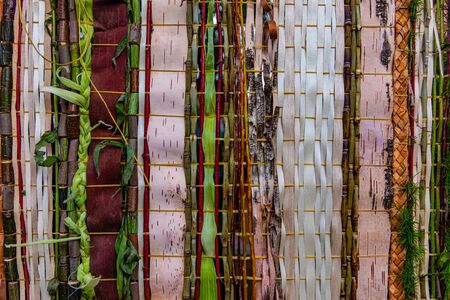 Closeup full frame shot of wooden bamboos and strips decoration with braided leaves representing...
