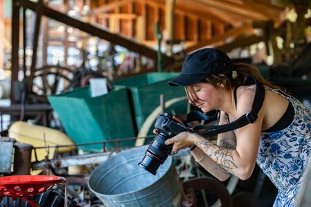 A visitor taking photos of old vintage machinery in the museum, Kootenays, British Columbia, Canada. Amateur photographer with camera checking photosの写真素材