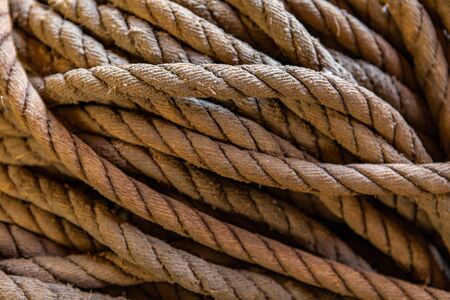 Bunch of old ropes on the sailing ship. Ropes background. Close-up view. A pile of aged ropes....