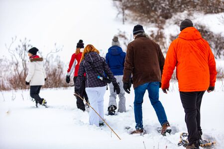 A group of people walking through the forest to have some rest. The walking people resting on a winter campsite in a forest.の写真素材