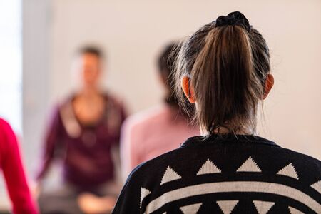 Girl in a yoga center making an exercise in a class. The woman meditating in the room. A taking part...