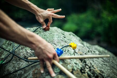 Close up selective focus shot of a spiritual man using modern implements to create music from a large boulder in nature, vibrational healing sounds with copy space.の写真素材