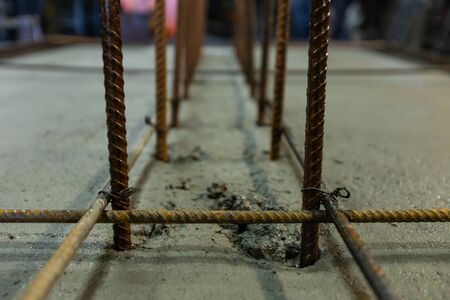 close up and selective focus view of foundation reinforcement steel bars on wet cement ground, structure in an interior construction site.の写真素材