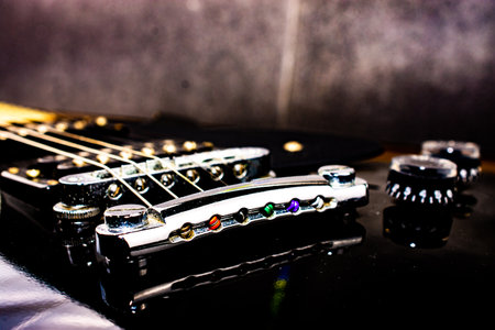 Black electric guitar with emphasis on the bridge and the volume knobs. Selective focus.の写真素材