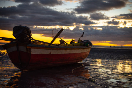 Fishing boat on the sandy beach of Jericoacoara, highlighted at sunset. Selective focus