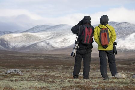 Man with binoculars looking for animals in landscape