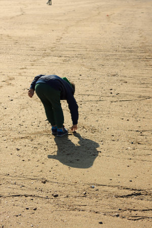 A boy drawing on sandの写真素材