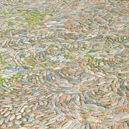 Background from the natural material of smooth multi-colored stones, decoration of the path in the...