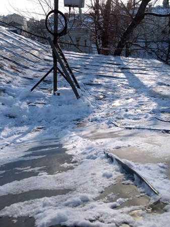The roof of the building is iron, rusty, old, covered with snow on a good winter day, view from above.の写真素材