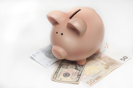 piggy bank with money isolated on whiteの写真素材