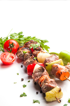 skewers on white background with vegetablesの写真素材