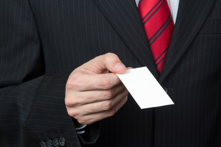 Unrecognizable businessman holding a card in handの写真素材