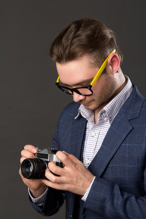 young photographer looking camera settings, studio pictureの写真素材