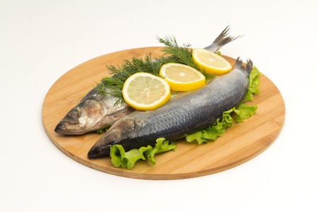 fish on cutting board on white backgroundの写真素材