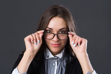 Portrait of a smiling businesswoman in glasses, studio pictureの写真素材
