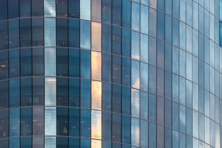 Office building skyscraper. building with panoramic glass windows reflecting the clouds....