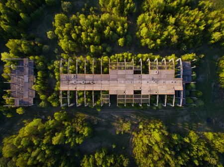 an unfinished, abandoned building overgrown with trees. conceptual backgroundの写真素材