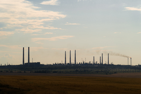 The silhouette of a huge gas and oil processing plant with burning torches, pipes and distillation of the complexの写真素材