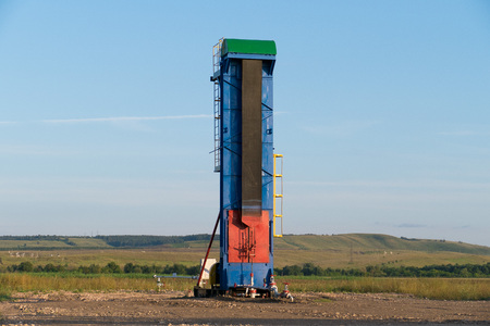 working oil pump on the ground among the green fieldsの写真素材