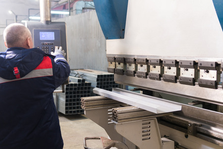 Operator working cut and bending metal sheet by high precision metal sheet bending machine, cnc control metal sheet bending machine in factoryの写真素材